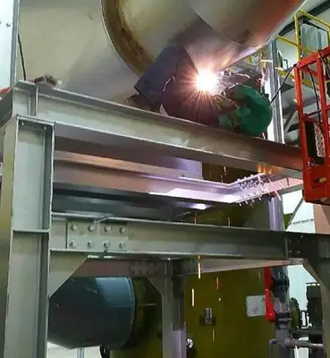 A certified welder running a structural weld on an industrial jobsite
